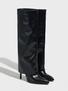 Nahaufnahme der Textur schwarzer spitzer Hosenbein-Stiefel mit hohem Absatz und langem Schaft