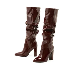 Detail of burgundy patent leather mid-calf boots with slouchy design and block heel