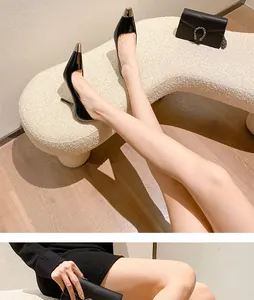 Close-up of black stiletto heels with elegant gold-toned metal toe cap
