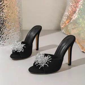 Gros plan détaillé de mules noires à talons aiguilles avec ornements en strass argent