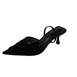 Detail view of elegant black mesh kitten heels with floral beadwork embroidery.