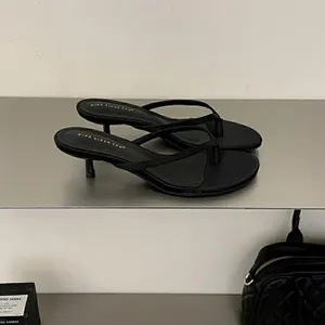 Eleganti sandali infradito neri con tacco a gattino dal design chic e minimalista.