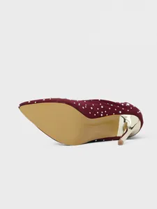 Close-up detail view of burgundy pointed toe stiletto boots with sparkling rhinestones