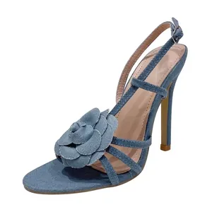 Elegante blauwe denim sandalen met hoge hakken, een groot roosornament en slanke bandjes