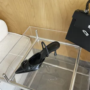 Detailed macro view of black pointed-toe high heel pump with elegant square buckle
