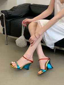 Detailed side view of metallic blue and gold color block wedge sandals on model