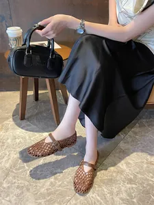Elegant brown hand-woven hollow-out Mary Jane flat shoes shown on model in cafe setting