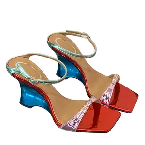 Macro view of metallic wedge sandals featuring vibrant color-blocking and crystal details