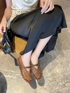 Close-up of brown handmade woven hollow-out Mary Jane flat shoes on model for summer wear