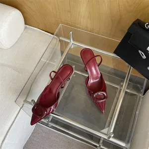 Detailed view of elegant burgundy patent leather pointed-toe high heels with large buckle