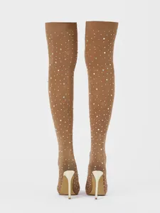 Detailed back view of over-the-knee boots with shimmering rhinestones and gold stiletto heels.