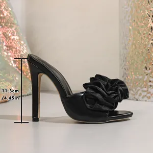 Side detail of 11.3cm stiletto heel on black mule sandal with fabric flower