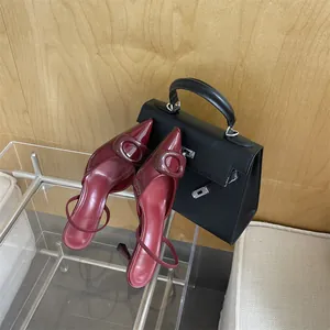 Elegant burgundy pointed-toe patent leather high heels with oval buckle detail