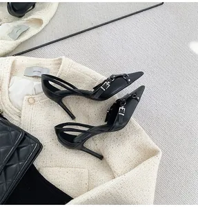 Detalle de los tacones de aguja negros de punta con elegante hebilla