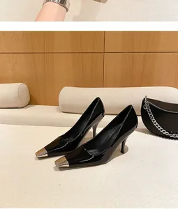 Detail of black patent leather stiletto high heels with stylish silver metal tips
