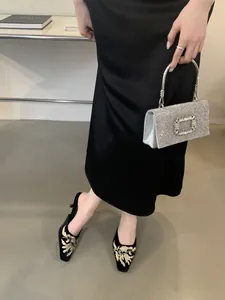 Vista detallada de chinelas bordadas de estilo chino con punta cuadrada y tacones de aguja fina