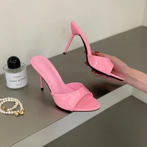 Detail view of pink patent leather high-heeled mule sandals with a thin heel