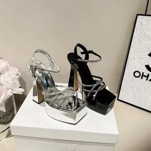 Dettaglio di eleganti sandali con tacco alto e cinturini in strass con plateau nero e argento