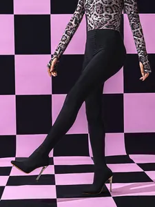 Dettaglio di leggings neri con décolleté a punta e tacchi a spillo integrati