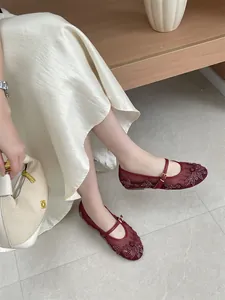 Close-up of wine-red mesh Mary Jane flat shoes with elegant floral embroidery and shiny rhinestones.