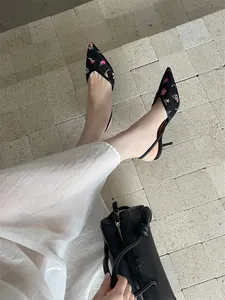 Elegantes zapatos de tacón slingback en malla negra con bordado floral rosa
