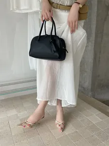 Detalle de elegantes zapatos destalonados de malla transparente con bordados florales.
