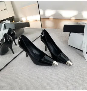 Detailed view of elegant black patent stiletto pumps with silver metallic pointed toe.