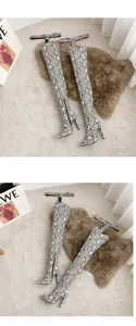 Close-up view of sexy snake print over-the-knee thigh-high boots with stiletto heels