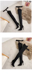 Detail view of black suede pointed toe over-the-knee stiletto boots with belt strap.