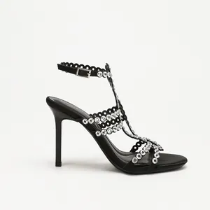 Elegante schwarze T-Steg-Stilettosandalen mit Strassverzierung auf weißem Hintergrund.