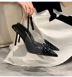 Detailed view of black pointed-toe stiletto heels with transparent PVC and slingback design