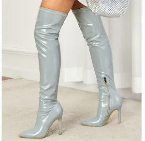Close-up of light grey patent leather over-the-knee boots with high stiletto heels