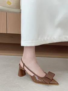 Side view of elegant brown pointed-toe slingback pumps with a bow and chunky heel.