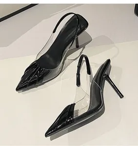 Detailed close-up showing the sleek black patent leather and clear PVC panels on these heels