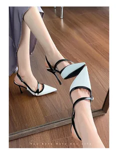 Close-up of white and black satin pointed-toe slingback heels with pearl detail