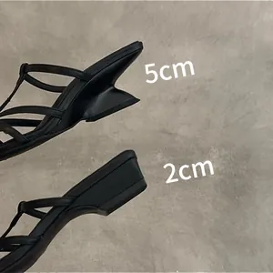 Comparaison détaillée entre le talon sculpté de 5 cm et le talon bloc de 2 cm sur sandales noires.