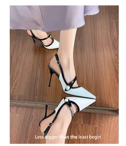 Elegant black and white pointed-toe slingback heels with pearl detail on a wooden floor.
