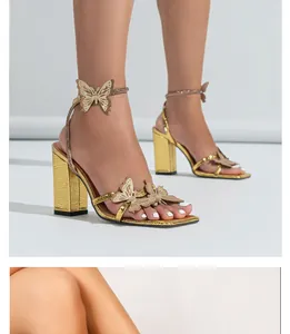 Detailed view of gold high-heeled sandals featuring butterfly accents and square toe