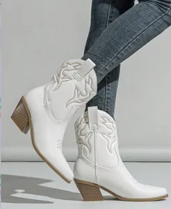 Detailed view of white Western cowboy boots with flame embroidery and high block heel
