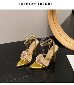 Vista de detalle de las sandalias doradas de tacón con flor de diamantes de imitación