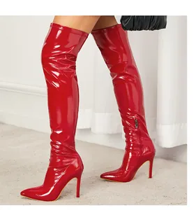 Detailed view of shiny red patent leather over-the-knee boots with pointed toe heels
