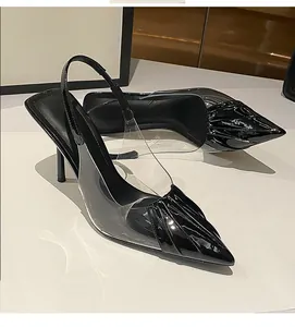 Detailed side view of black patent leather pointed-toe slingback heels with clear PVC