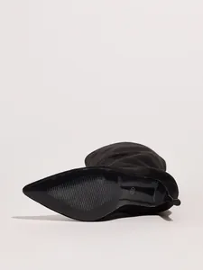 Detailed view of the anti-slip sole on black suede pointed toe stiletto boots