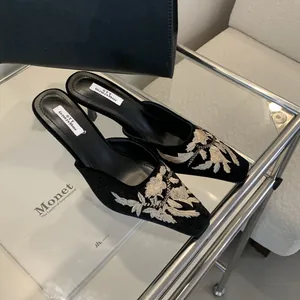 Detalle elegante de mules bordados de estilo chino con punta cuadrada y tacones de aguja finos
