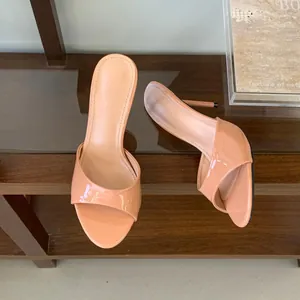 Detail of elegant nude patent leather high-heeled mules with 9cm stiletto heels.