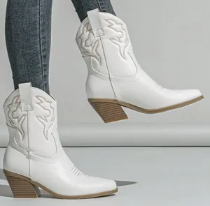 Side view detail of white embroidered western cowboy boots with a chunky stacked heel.