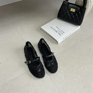 Detailed view of black mesh flat shoes with elegant floral embroidery and sequins.