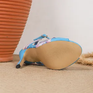Detalle de sandalia de tacón de aguja azul con flores y suela antideslizante elegante