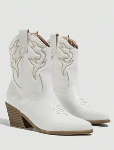 Detailed view of white Western cowboy boots with intricate brown embroidery patterns