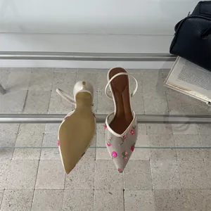 Detalle del elegante bordado floral y la parte superior de malla de los tacones slingback vintage